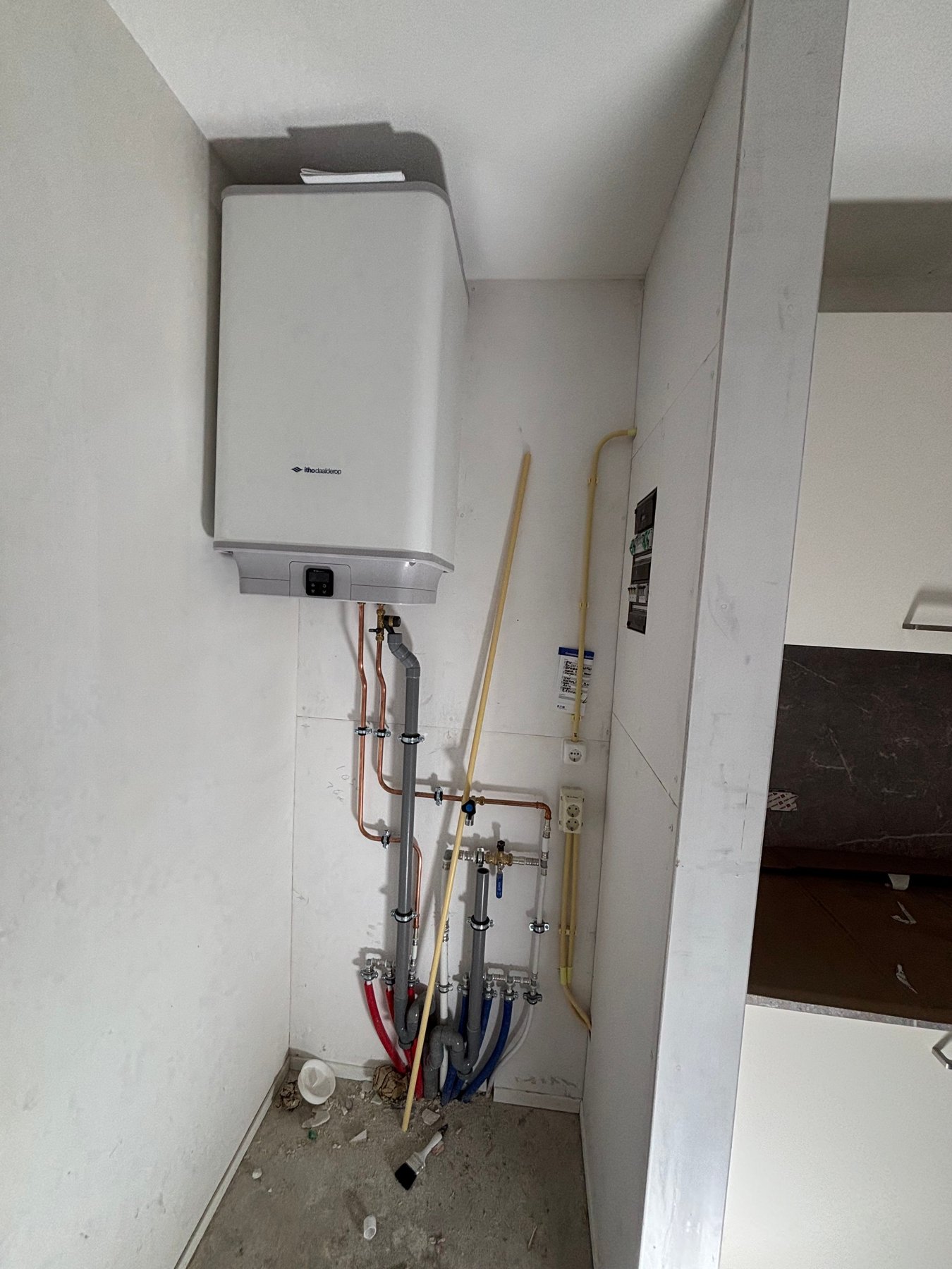Nieuwe cv-ketel in een smalle kast met nieuw leidingwerk