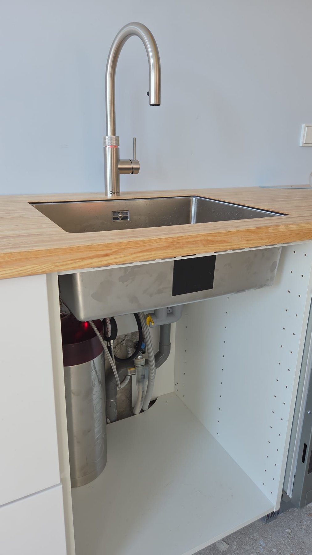 Kokendwaterkraan op een houten aanrechtblad met rvs spoelbak