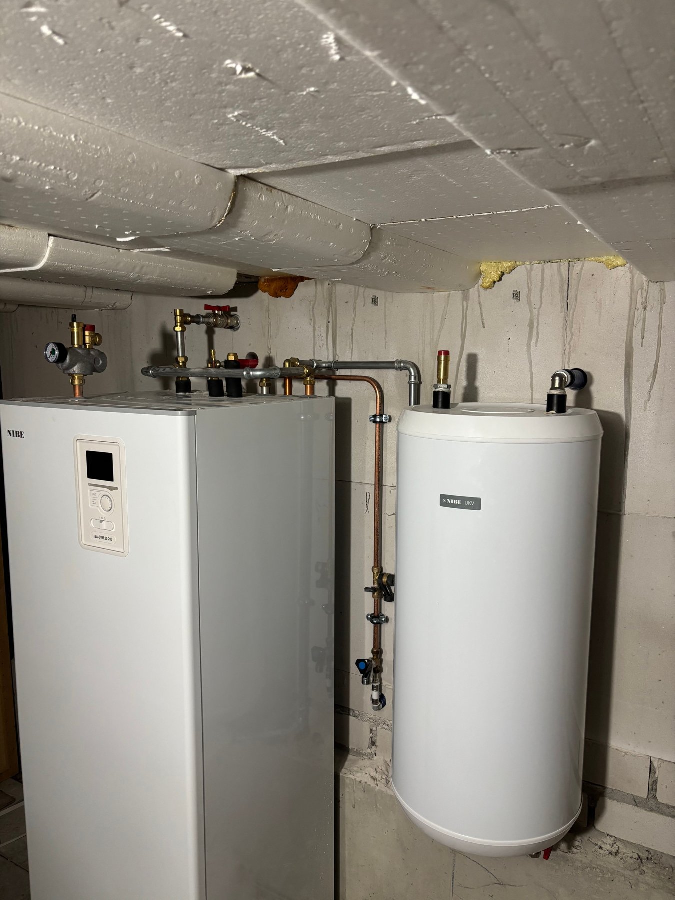 Nieuw geplaatste warmtepomp en boilervat in een technische ruimte